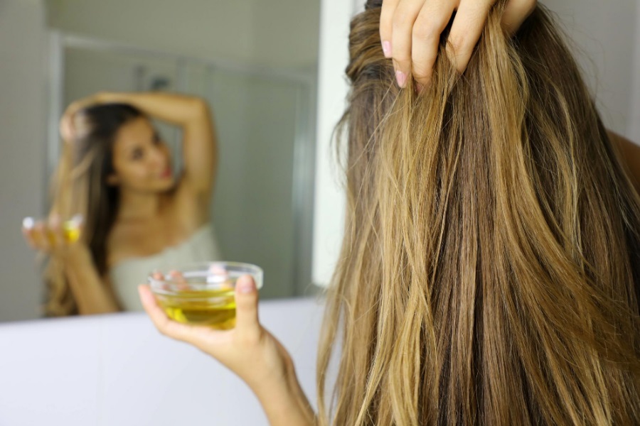 Kobieta z kręconymi włosami olejująca włosy na sucho